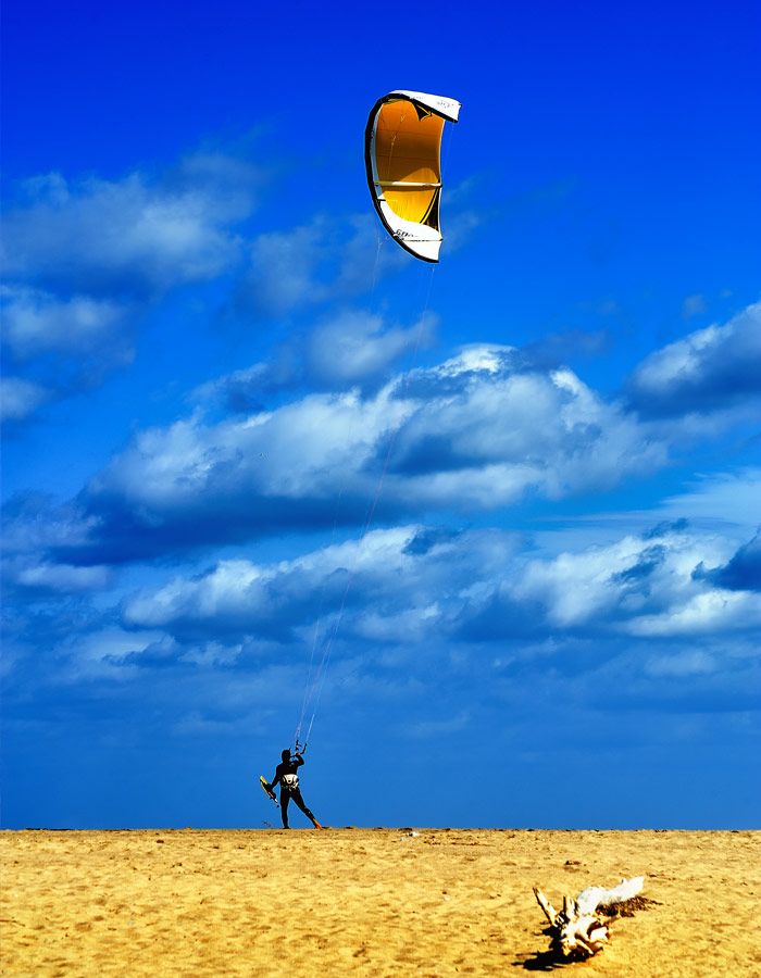 Turista pratica paragliding durante le sue vacanze sull'Isola Rossa